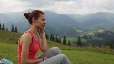 Young woman communicating with mobile phone on the top of mountain with beautiful canyon on background