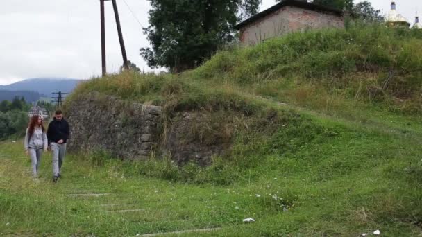 Hermosa pareja caminando en ferrocarril en las montañas juntos — Vídeo de stock