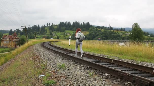 Mujer caminando en el ferrocarril en las montañas — Vídeos de Stock