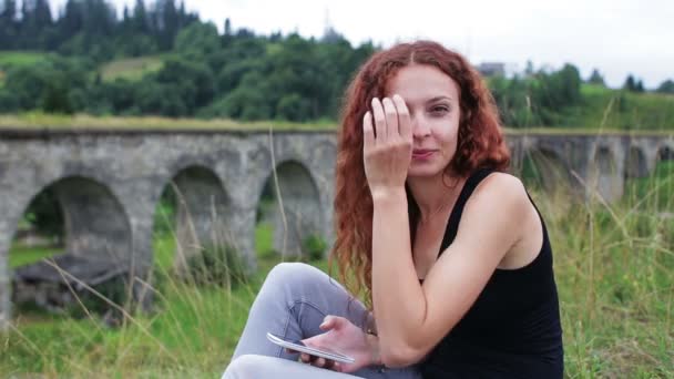 Meisje dansen terwijl u zit in de buurt van het oude viaduct in de bergen — Stockvideo