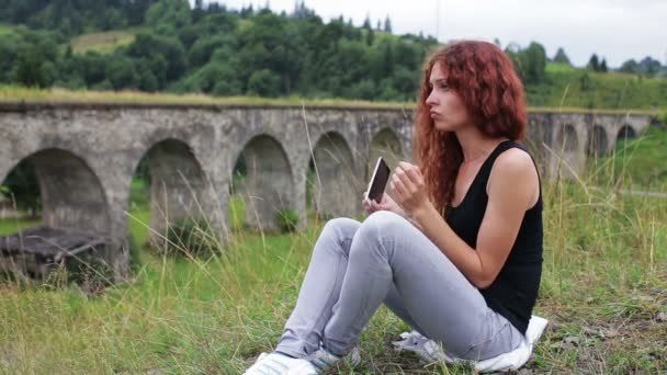 Κορίτσι χορό ενώ κάθεται κοντά στο παλιό viaduct στα βουνά — Αρχείο Βίντεο