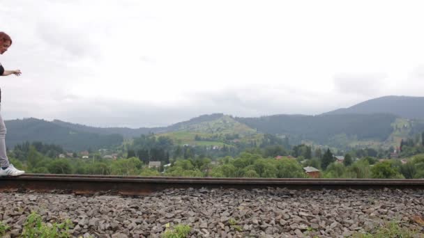 Mujer caminando en el ferrocarril en las montañas — Vídeo de stock