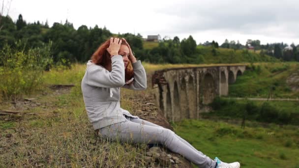 Dívka sedí na starý viadukt — Stock video