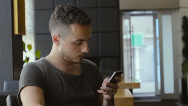 Hombre usando el teléfono móvil y beber café en el restaurante — Vídeo de stock