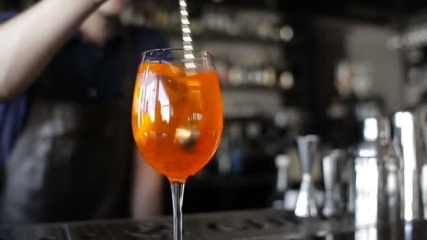 De barman mengt de ingrediënten in het glas. Stokken en cocktail rietjes in het glas. — Stockvideo