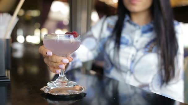 Красива жінка п'є коктейль наодинці в барі — стокове відео