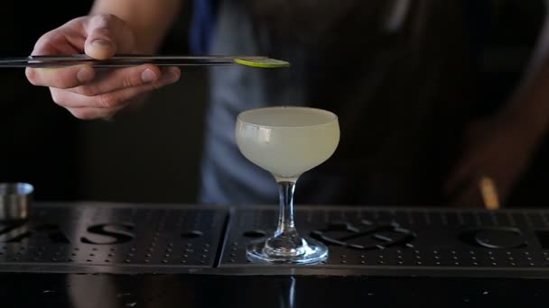 The hands of the bartender garnish the cocktail with lime — Stock Video