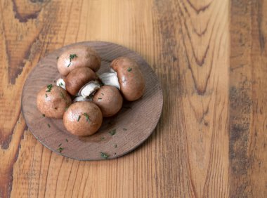 Tahta bir masada, tabakta mantarlar