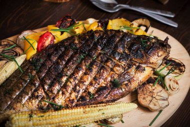 Sebze, mısır, biber ve domatesle pişirilmiş balık sazan balığı. Yatay üst görünüm