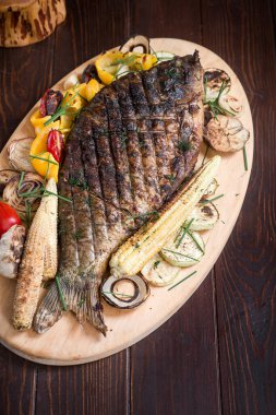 Sebze, mısır, biber ve domatesle pişirilmiş balık sazan balığı. Dikey üst görünüm