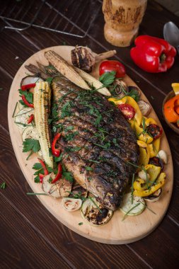 Sebze, mısır, biber ve domatesle pişirilmiş balık sazan balığı. Dikey üst görünüm