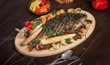 Sebze, mısır, biber ve domatesle pişirilmiş balık sazan balığı. Yatay üst görünüm