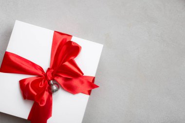 Beton kaplama kırmızı kurdeleli beyaz Noel hediyesi kutusu. Metin için yer