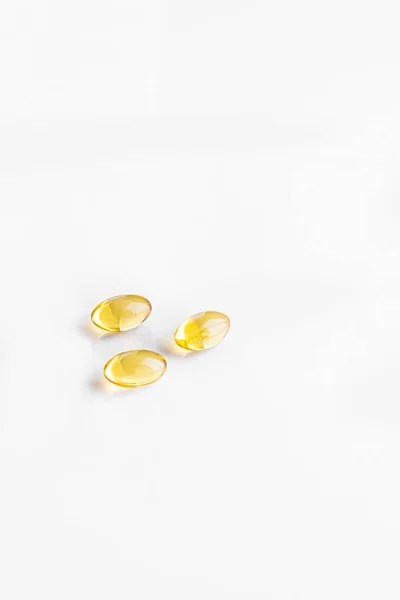 Beyaz arka planda izole edilmiş Omega-3 balık yağı takviye kapsülleri.