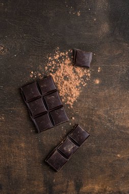 Koyu ahşap arka planda koyu çikolata çubuğu