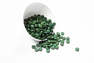 Beyaz arka planda yeşil oval takviye hapları yığını