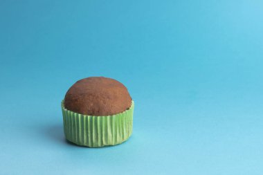 Çikolatalı kek, pasta, karamel sosu, çikolata parçacıkları, çikolatalı kek, yeşil kağıt şeklinde karamel kek. Açık mavi bir arkaplanda.