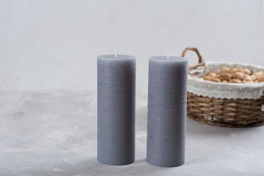 Gri masadaki gri mumlar, sepetteki cevizler. Beyaz arka plan. Metnin için yer.