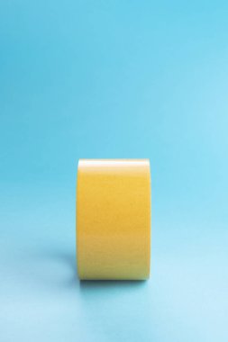 Bir rulo koli bandı, mavi dikey arkaplan bandı. Metin için yer.