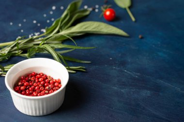 Baharatlar, kırmızı biberler ve otlar. Mavi arka planda, yakın planda. Metin için yer.