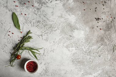 Baharatlar, kırmızı biberler ve otlar. Gri bir arka planda. Metin için yer.