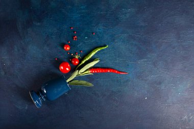 Domateslerin üst görüntüsü, mavi arka planda kırmızı acı biber. Metin için yer.