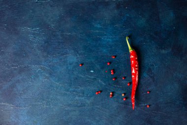 Mavi arka planda kırmızı kırmızı kırmızı biber. Metin için yer.