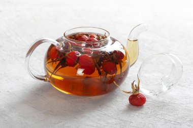 Arka planda şeffaf bir su ısıtıcısının içinde güllük gülistanlık çay