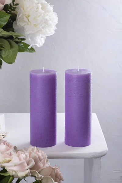 紫色的蓝色蜡烛 一束鲜花 放在白桌上 白色垂直背景 — 图库照片