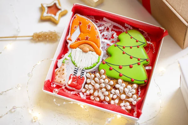 Noel 'de ev yapımı zencefilli kurabiyeler, şenlikli bir cüce ve Noel ağacı şeklinde, arka planda Noel süslemeleri. Yakın plan..