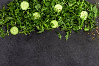 Taze sebzeler roka, salatalık, bitkiler, biber ve gri dokulu arka planda zeytinler. Yukarıdan bak. Alta metin yerleştir, boşluğu kopyala.