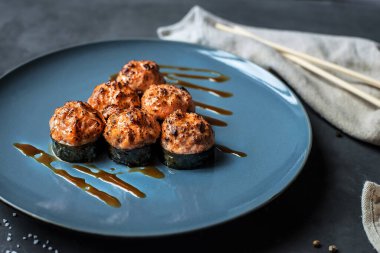 Japon suşisi yakın plan. Üst görünüm mavi plaka, koyu gri arkaplan.