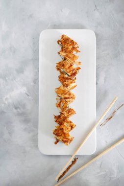 Japon suşisi yakın plan. Beyaz plaka üzerinde üst görünüm, açık gri dikey arkaplan.