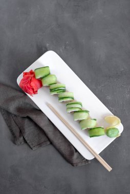 Japon suşisi yakın plan. Üst görünüm beyaz plaka, koyu gri arkaplan.