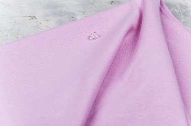 Leylak kumaşında boncuk. Doğal lif kumaşı. Açık gri arkaplan.