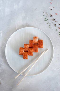 Japon suşisi yakın plan. Üst görünüm beyaz plaka, açık gri desenli arkaplan.