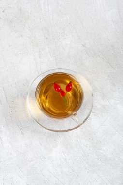 Rosehip çayı, cam fincanda tıbbi gül çayı gri arka plan manzarası