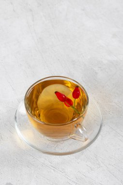 Rosehip çayı, cam fincanda tıbbi gül çayı gri arka plan