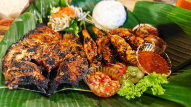 Muz yaprağında ızgara deniz ürünleri tabağı