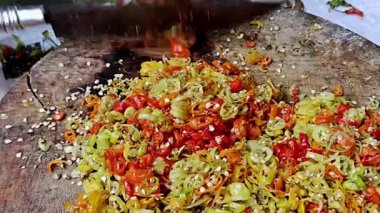 Köy ahşap kesme tahtasının üzerinde şefin bıçağıyla doğranmış taze kırmızı biber.