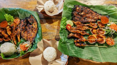 Endonezya usulü ızgara deniz ürünleri ziyafeti. Muz yapraklı karides ve pilav.