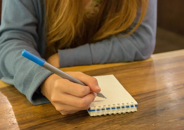 ペンでノートに書く女性の手 — ストック写真