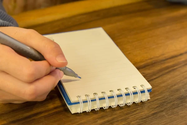 Mani femminili con scrittura a penna su taccuino — Foto Stock