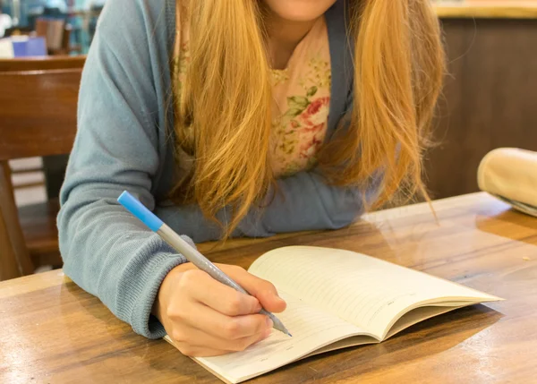 Female hands with pen writing on notebook — Stock Photo, Image