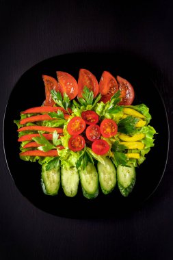 Mor lahanalı taze sebze salatası, beyaz lahana, marul, siyah arka planda koyu kil kasede havuç. Üst görünüm