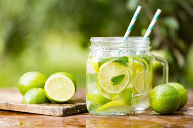Ahşap arka plan üzerinde mason kavanoza taze içecek limonata mojito. Mojito nane yaprakları, kireç ve buz, açık.