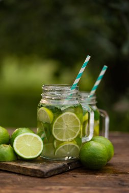 Ahşap arka plan üzerinde mason kavanoza taze içecek limonata mojito. Mojito nane yaprakları, kireç ve buz, açık.