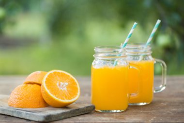 Taze portakal suyu ve ahşap masa üzerinde olgunlaşmış dilimlenmiş.