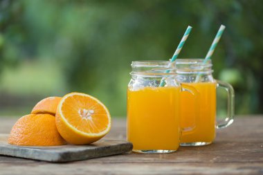 Taze portakal suyu ve ahşap masa üzerinde olgunlaşmış dilimlenmiş.