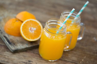 Taze portakal suyu ve ahşap masa üzerinde olgunlaşmış dilimlenmiş.